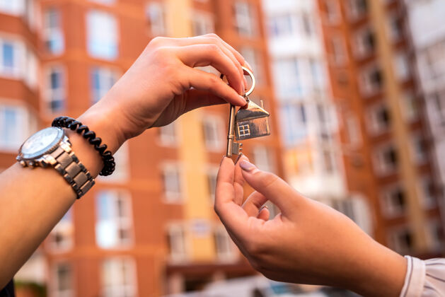 房主房地产经纪人正在为新房主递房子钥匙住宅销售或者租回家投资经纪人房子