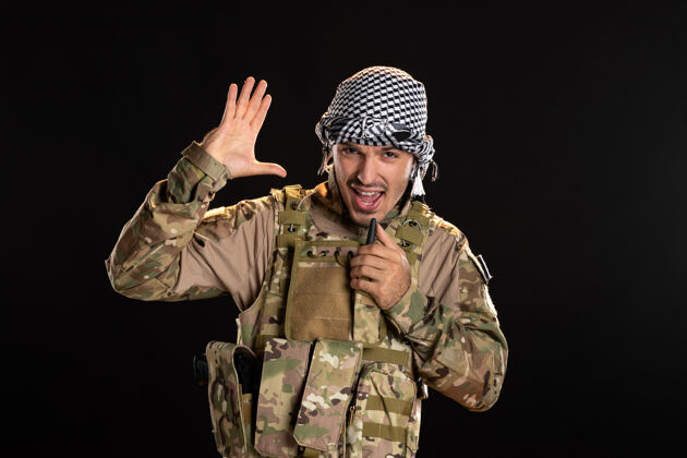 帽子身着军装的巴勒斯坦士兵正在通过无线电台的黑墙讲话盔甲肖像掩护