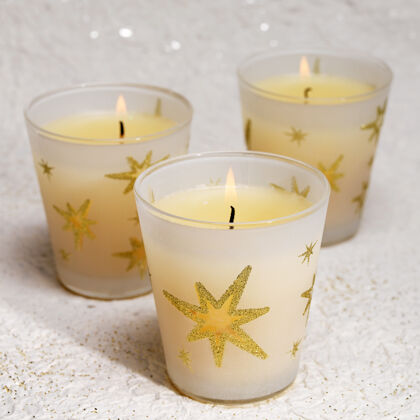 圣诞快乐三支燃烧着的蜡烛和一颗星星放在玻璃杯里诺埃尔问候冬青