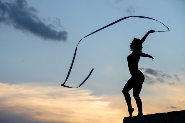 动作职业体操女子舞蹈演员 丝带飘扬在天空平衡乐趣女性