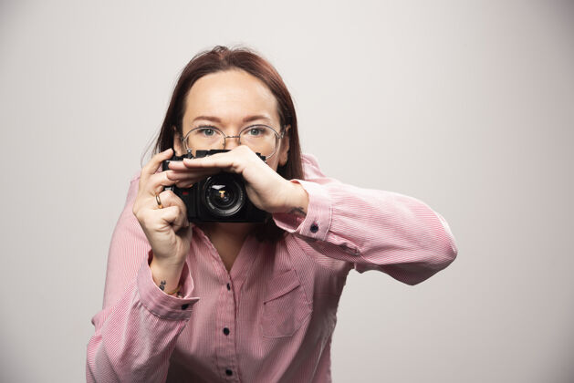成人用白色相机拍照的女人高质量的照片电影时尚女士