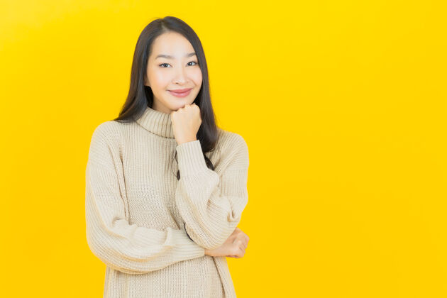 时尚美丽的亚洲年轻女子在黄色的墙上微笑脸学生漂亮