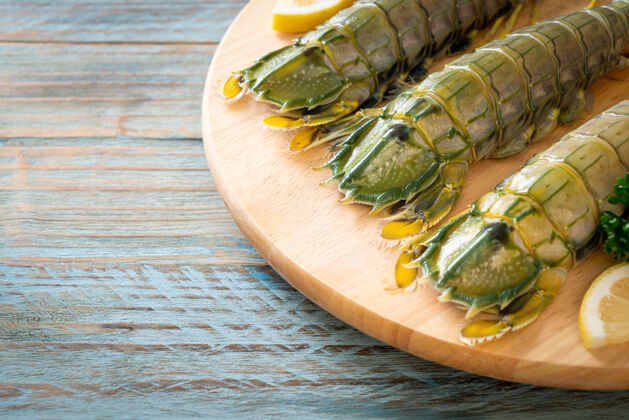 爪新鲜的柠檬螳螂虾在木板上板亚洲烹饪