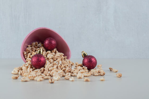 生的一个装满健康麦片和圣诞球的粉红色碗新鲜脆的有机食品