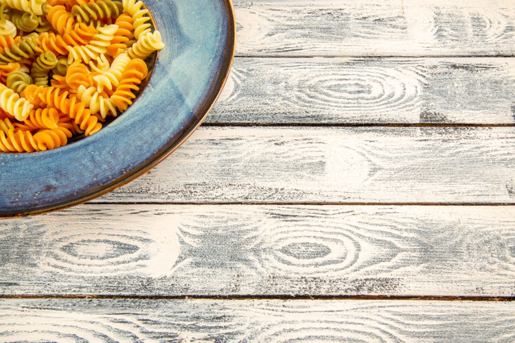不寻常正面图美味的意大利面食不寻常的煮熟螺旋面食在灰色的木制桌子上烹饪晚餐面团面食财务沙子货币