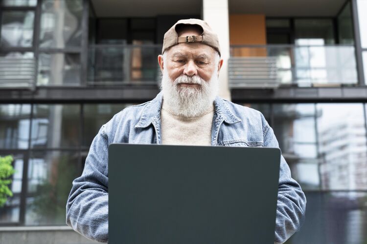 老年在城市户外使用笔记本电脑的老人退休笔记本电脑老年人