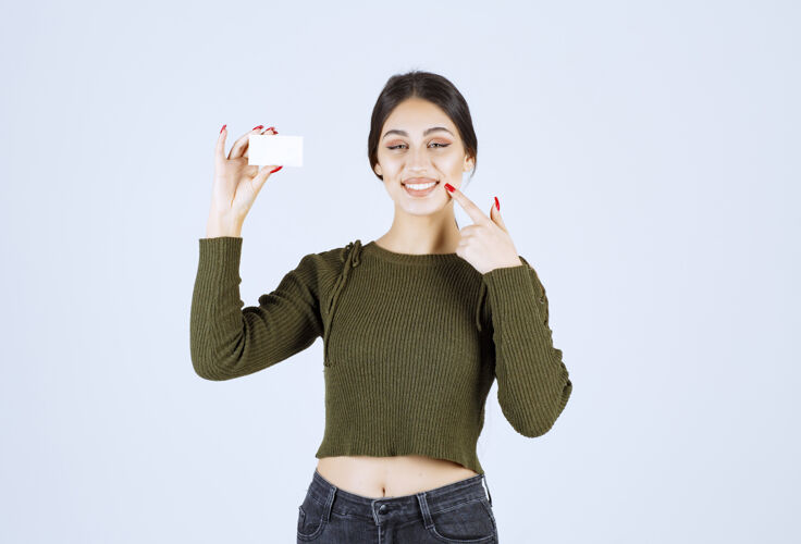 空白快乐女人的肖像 展示空白名片 指着她的嘴商业复制空间女孩