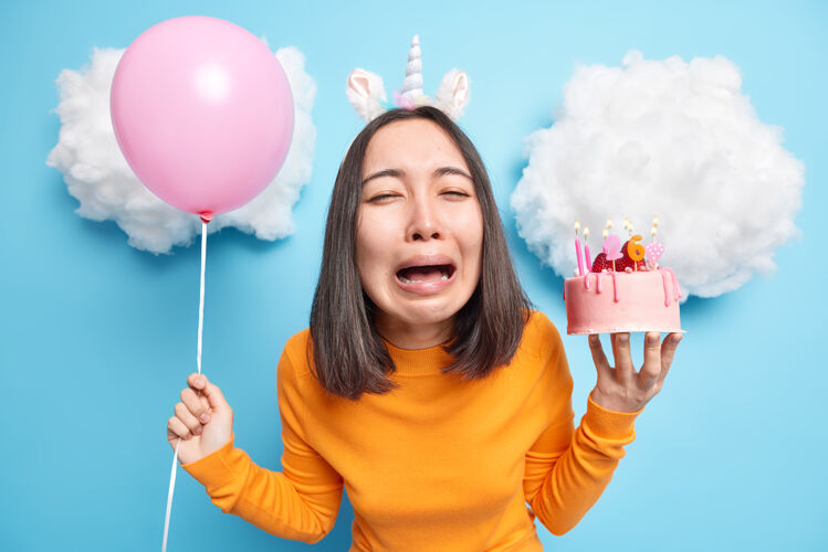 消极女人绝望地哭着拿着充气气球和美味的甜点过生日心情不好悲伤个体水平