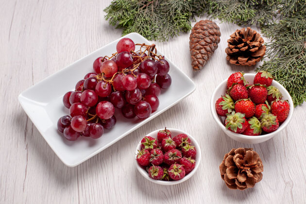 红葡萄干正面是新鲜的葡萄和水果 白色的桌子上有水果醇厚的果汁颜色葡萄干水果甜点