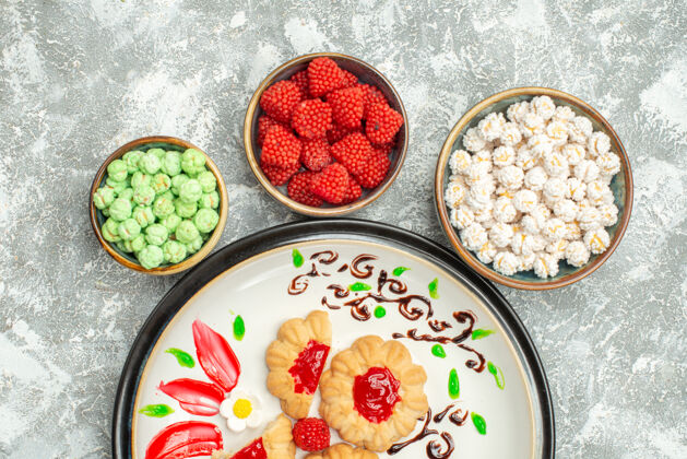 风景俯瞰美味的甜饼与红色果冻和糖果的白色背景甜饼蛋糕饼干茶早餐盘子蔬菜