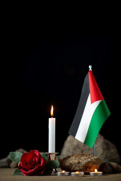火黑暗中燃烧着蜡烛的巴勒斯坦国旗正面图火焰燃烧光