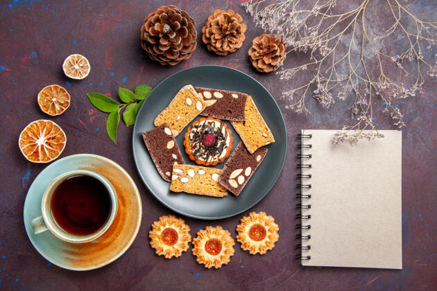 盘子俯瞰美味的蛋糕片配上小饼干和一杯茶 背景为深色饼干甜点蛋糕茶甜美食甜点美味蛋糕片