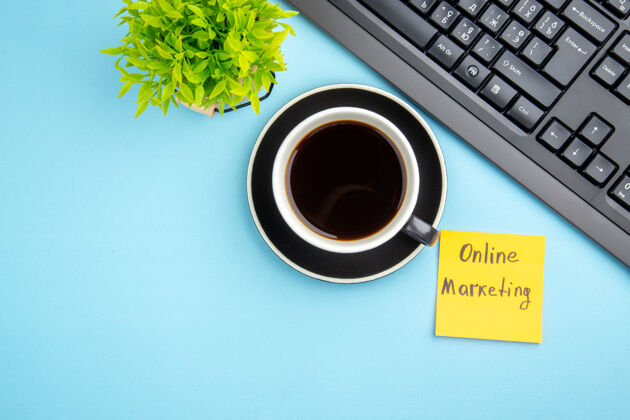 咖啡因一杯红茶和蓝色背景上的在线营销书写花朵 俯瞰办公室概念杯子红茶市场营销