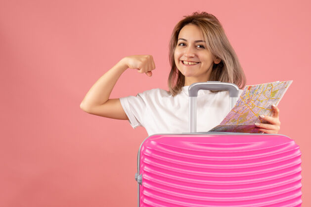 漂亮正面图：年轻女孩拿着粉色手提箱 地图上显示手臂肌肉肖像冒险可爱