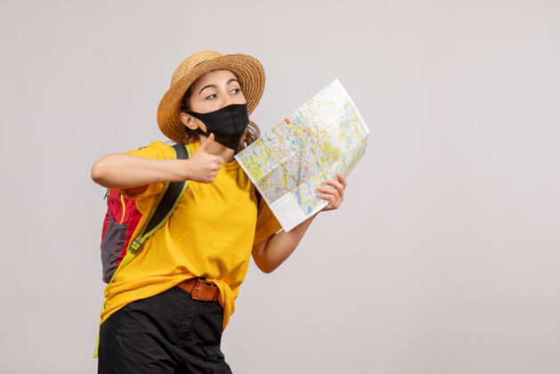 旅游正面图年轻的旅行者背着背包举着地图竖起大拇指旅行者女人新常态