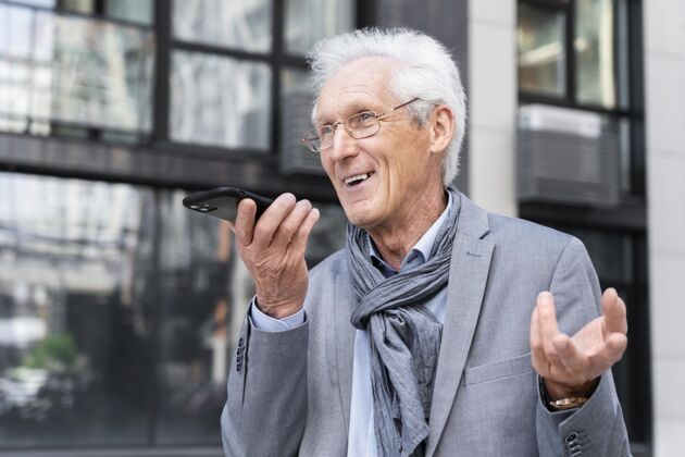 老年城里的一个老男人在用智能手机聊天城市城市男性