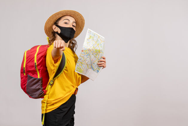 背包正面图年轻的旅行者背着红色的背包举着地图向上旅游度假
