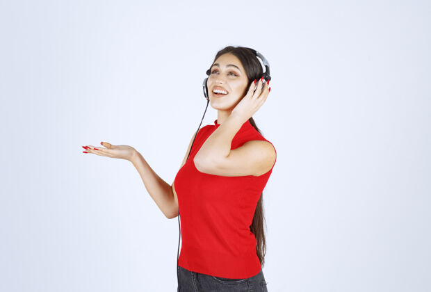 人类穿着红衬衫的Dj女孩 戴着耳机 手上拿着什么东西或是什么东西模特工作人员场景