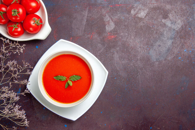 桶俯瞰美味的西红柿汤配上新鲜的西红柿 背景色为深色的酱汁西红柿汤汤餐汤碗