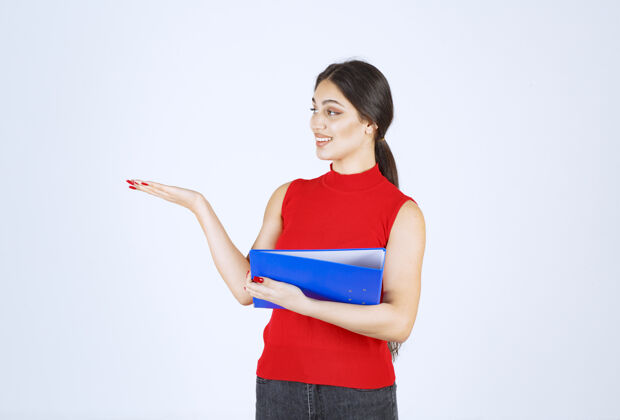 项目穿着红衬衫的女孩手里拿着一个蓝色的商业文件夹人类助理休闲