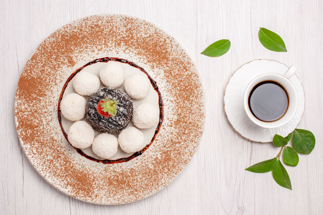蛋糕俯瞰美味的椰子糖配巧克力蛋糕和一杯白底茶蛋糕饼干糖果饼干甜盘子甜点瓷器