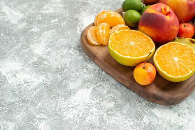 柠檬正面视图不同的水果组成切片和整个新鲜水果在一个白色的空间醇香新鲜柑橘