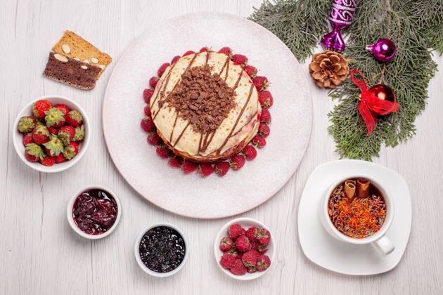 餐厅俯瞰美味的草莓煎饼和一杯茶在白色桌子上馅饼蛋糕水果饼干甜浆果食物桌子景观