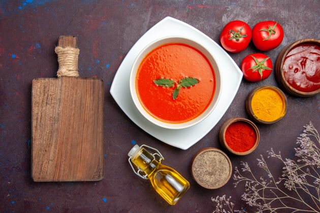 餐厅俯瞰美味的番茄汤配上不同调味料的深色背景菜酱番茄色一餐汤顶部盘子景观