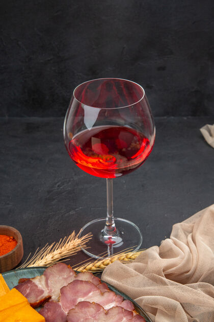 玫瑰前视图的红玫瑰在玻璃酒杯红玫瑰小吃和胡椒在黑暗的背景餐厅葡萄酒正面