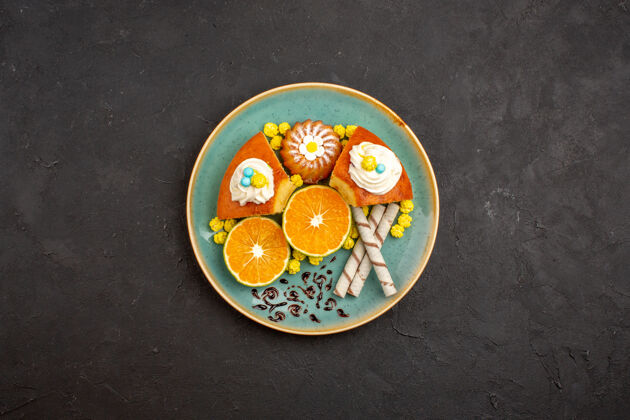 视图俯瞰美味的蛋糕片与烟斗饼干和切片橘子上的深色背景水果柑橘蛋糕派饼干甜茶盘子烟斗美味的蛋糕切片