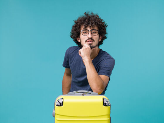 人带着浅蓝色大黄色手提箱的度假男人旅行大肖像