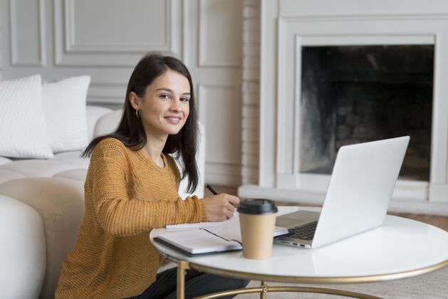 女人正在用笔记本电脑的年轻女人房子通讯科技