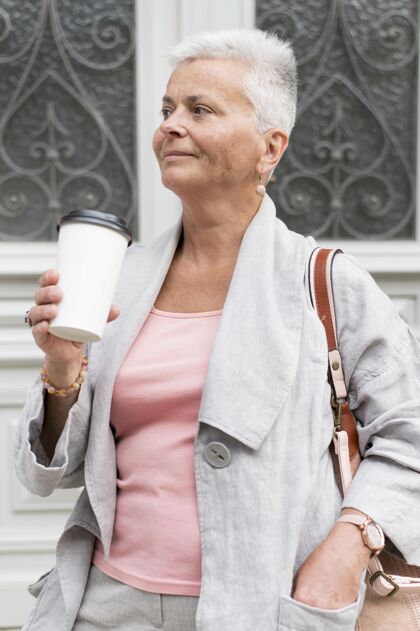 老年人拿着咖啡杯的中枪女人城市老年人女性
