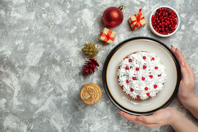 针叶树手拿美味蛋糕的顶视图 盘子上放着奶油葡萄干和礼盒圆锥形水果食物