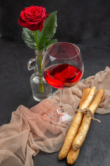香槟上图：黑色背景上 毛巾上的玻璃高脚杯里的红酒盘子早餐晚餐