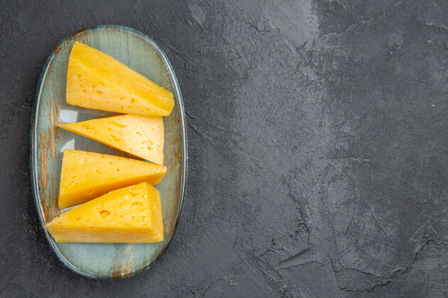 水果俯视图美味的黄色切片奶酪在一个蓝色的盘子在右边的黑色背景可食用水果美食健康