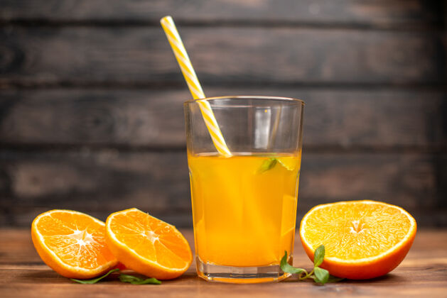 木头木桌上盛着新鲜橙汁的玻璃杯 上面放着薄荷和橙汁橙汁水果服务