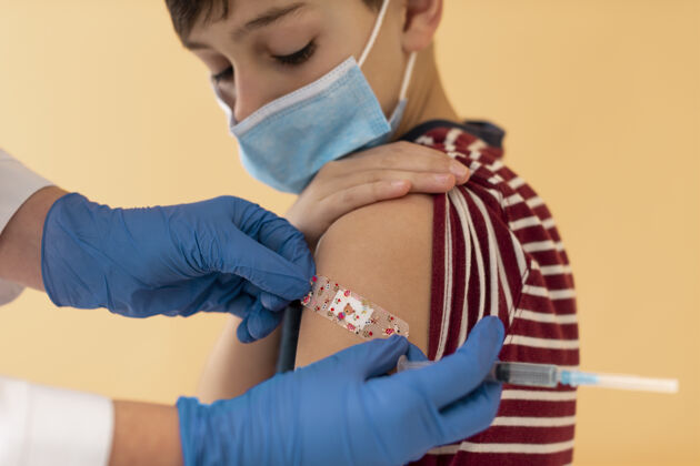 男孩给孩子打疫苗后特写医生面罩特写