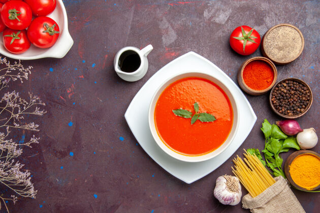 食物俯瞰美味的西红柿汤配上新鲜的西红柿和调味料上深色的桌上菜一餐酱汁西红柿色汤新鲜视图容器