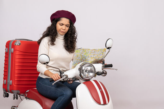骑前视图年轻女性骑自行车在白色背景上观察地图城市彩色道路度假车摩托车行驶速度年轻女性成人速度