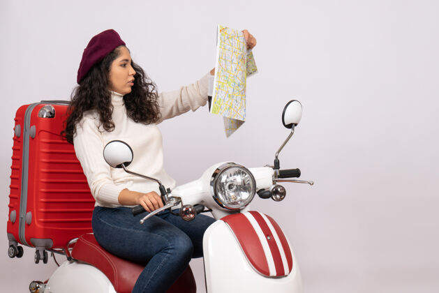 地图前视图年轻女性骑自行车在白色背景上观察地图城市彩色道路度假车摩托车行驶速度骑成人漂亮