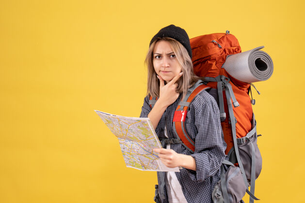 姿势体贴的女旅行者背着背包拿着地图女士脸背包