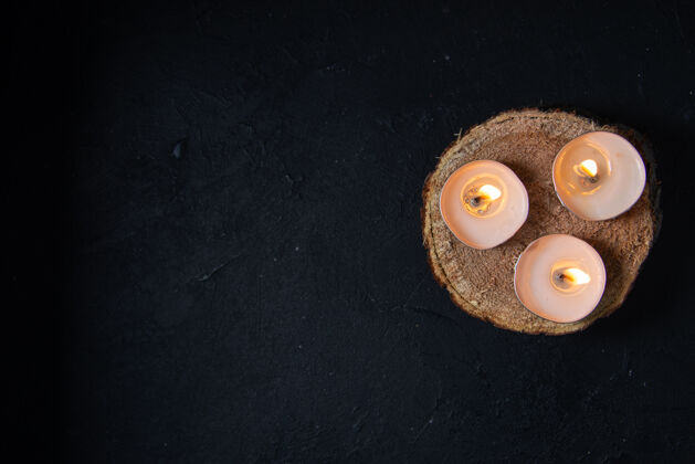 桌子黑色墙上燃烧蜡烛的顶视图燃烧的蜡烛葬礼顶部