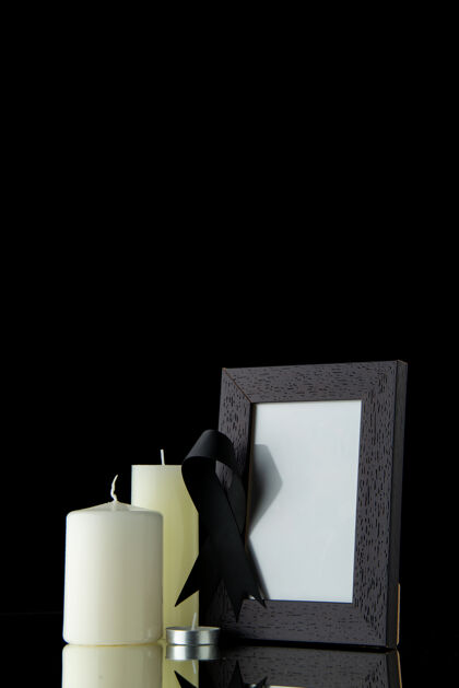 葬礼黑墙上带相框的白色蜡烛的正面图图片死亡视图
