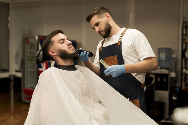 美容师在理发店理胡子的年轻人修剪者专业乳胶手套