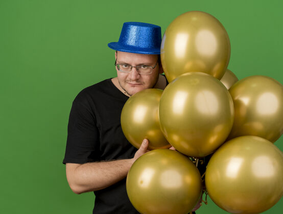 帽子邪恶快乐的成年斯拉夫人戴着眼镜戴着蓝色派对帽拿着氦气球举行聚会空间