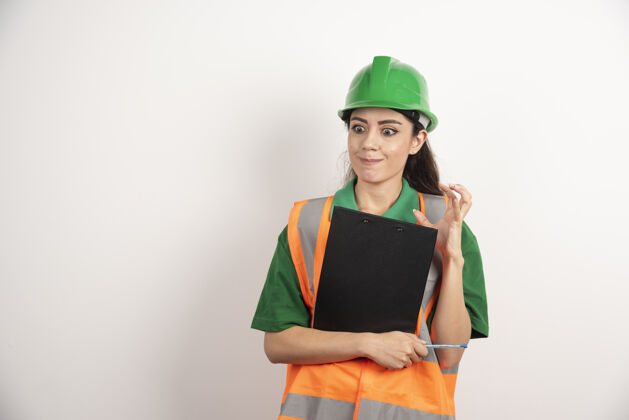 女人愤怒的女工程师与剪贴板上的白色背景高品质的照片安全帽工人人