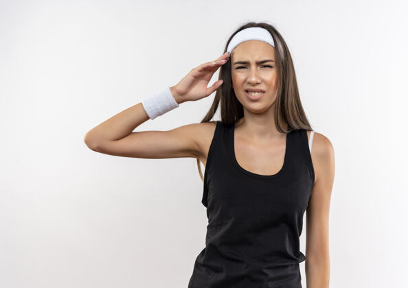 运动恼怒漂亮的运动女孩戴着头带和腕带把手放在头附近隔离在白墙上头带近烦