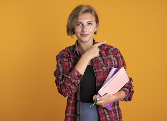 笔记本自信的年轻斯拉夫女学生手边拿着笔本和笔记本空间学生橙色