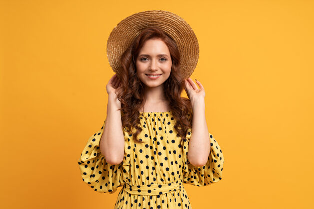 女性时髦的红发女人穿着黄色的裙子摆姿势 袖子是黄色的夏天的心情趋势积极女士